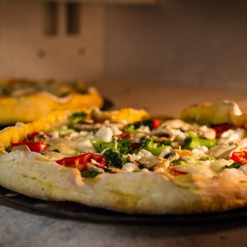La pizza è uno dei piatti più amati e consumati al mondo, ma spesso viene vista con una certa preoccupazione da chi deve monitorare i livelli di zucchero nel sangue. La combinazione di carboidrati e grassi nella pizza può infatti causare un aumento dell’indice glicemico, ma esistono strategie per abbassarlo e renderla un piatto più equilibrato. Scopriamo insieme cosa mangiare con la pizza per ridurre l’impatto glicemico e godere di una cena gustosa senza compromettere la salute. L’importanza dell’indice glicemico L’indice glicemico (IG) è un parametro che misura la velocità con cui i carboidrati presenti in un alimento vengono trasformati in zuccheri nel sangue. Alimenti con un alto IG, come la pizza tradizionale, possono provocare picchi rapidi di glicemia, che nel tempo possono aumentare il rischio di malattie come il diabete. Fortunatamente, con alcune scelte alimentari, è possibile ridurre questo effetto. Aggiungere proteine per bilanciare l’indice glicemico Una delle strategie più efficaci per abbassare l’indice glicemico della pizza è quella di aggiungere proteine al pasto. Le proteine, infatti, rallentano l’assorbimento dei carboidrati, contribuendo a mantenere stabili i livelli di zucchero nel sangue. Per esempio, si può accompagnare la pizza con del pollo grigliato, del prosciutto crudo, o del formaggio magro come la mozzarella. Le uova sono un’altra fonte proteica eccellente da aggiungere come topping. Scegliere verdure ricche di fibra Le verdure sono un’ottima aggiunta alla pizza, poiché sono ricche di fibre che contribuiscono a rallentare la digestione e l’assorbimento dei carboidrati. Optare per verdure come spinaci, broccoli, rucola o zucchine, oltre a rendere il piatto più sano, aiuta anche a ridurre l’indice glicemico. Le fibre favoriscono una digestione più lenta e costante, evitando sbalzi glicemici improvvisi. Optare per una base integrale Un altro modo per abbassare l’indice glicemico della pizza è scegliere una base integrale o, meglio ancora, una base a base di farina di avena. La farina integrale contiene una maggiore quantità di fibre rispetto alla farina bianca, il che rallenta l’assimilazione dei carboidrati. In questo modo, il corpo impiega più tempo per digerire la pizza, evitando picchi di glicemia. Evitare troppi condimenti ricchi di zucchero Spesso, i condimenti per pizza, come salse o ketchup, contengono zuccheri aggiunti che possono aumentare l’indice glicemico. È quindi consigliabile evitare l’uso di queste salse zuccherate e optare per un condimento più naturale, come salsa di pomodoro semplice, olio d’oliva extravergine e basilico. Questi ingredienti sono ricchi di antiossidanti e acidi grassi sani, che migliorano la salute generale senza aumentare la glicemia. Integrare con una bevanda a basso contenuto di zucchero Anche la bevanda che accompagna la pizza può influire sull’indice glicemico del pasto. Evitare bibite gassate e zuccherate è fondamentale. Una buona alternativa può essere l’acqua, ma anche tè verde o tisane senza zucchero sono scelte eccellenti. Questi bevande non solo non alzano la glicemia, ma apportano anche benefici antiossidanti e digestivi. Conclusione: come godersi una pizza equilibrata In conclusione, mangiare una pizza può essere parte di una dieta equilibrata anche per chi vuole tenere sotto controllo l’indice glicemico. La chiave sta nell'accompagnare la pizza con alimenti ricchi di proteine, fibre e grassi sani, evitando condimenti zuccherati e preferendo una base integrale. Così facendo, si potrà gustare una pizza sana, senza rinunciare al piacere e mantenendo sotto controllo la glicemia.