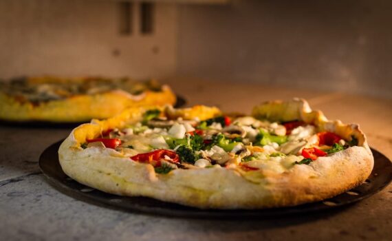 La pizza è uno dei piatti più amati e consumati al mondo, ma spesso viene vista con una certa preoccupazione da chi deve monitorare i livelli di zucchero nel sangue. La combinazione di carboidrati e grassi nella pizza può infatti causare un aumento dell’indice glicemico, ma esistono strategie per abbassarlo e renderla un piatto più equilibrato. Scopriamo insieme cosa mangiare con la pizza per ridurre l’impatto glicemico e godere di una cena gustosa senza compromettere la salute. L’importanza dell’indice glicemico L’indice glicemico (IG) è un parametro che misura la velocità con cui i carboidrati presenti in un alimento vengono trasformati in zuccheri nel sangue. Alimenti con un alto IG, come la pizza tradizionale, possono provocare picchi rapidi di glicemia, che nel tempo possono aumentare il rischio di malattie come il diabete. Fortunatamente, con alcune scelte alimentari, è possibile ridurre questo effetto. Aggiungere proteine per bilanciare l’indice glicemico Una delle strategie più efficaci per abbassare l’indice glicemico della pizza è quella di aggiungere proteine al pasto. Le proteine, infatti, rallentano l’assorbimento dei carboidrati, contribuendo a mantenere stabili i livelli di zucchero nel sangue. Per esempio, si può accompagnare la pizza con del pollo grigliato, del prosciutto crudo, o del formaggio magro come la mozzarella. Le uova sono un’altra fonte proteica eccellente da aggiungere come topping. Scegliere verdure ricche di fibra Le verdure sono un’ottima aggiunta alla pizza, poiché sono ricche di fibre che contribuiscono a rallentare la digestione e l’assorbimento dei carboidrati. Optare per verdure come spinaci, broccoli, rucola o zucchine, oltre a rendere il piatto più sano, aiuta anche a ridurre l’indice glicemico. Le fibre favoriscono una digestione più lenta e costante, evitando sbalzi glicemici improvvisi. Optare per una base integrale Un altro modo per abbassare l’indice glicemico della pizza è scegliere una base integrale o, meglio ancora, una base a base di farina di avena. La farina integrale contiene una maggiore quantità di fibre rispetto alla farina bianca, il che rallenta l’assimilazione dei carboidrati. In questo modo, il corpo impiega più tempo per digerire la pizza, evitando picchi di glicemia. Evitare troppi condimenti ricchi di zucchero Spesso, i condimenti per pizza, come salse o ketchup, contengono zuccheri aggiunti che possono aumentare l’indice glicemico. È quindi consigliabile evitare l’uso di queste salse zuccherate e optare per un condimento più naturale, come salsa di pomodoro semplice, olio d’oliva extravergine e basilico. Questi ingredienti sono ricchi di antiossidanti e acidi grassi sani, che migliorano la salute generale senza aumentare la glicemia. Integrare con una bevanda a basso contenuto di zucchero Anche la bevanda che accompagna la pizza può influire sull’indice glicemico del pasto. Evitare bibite gassate e zuccherate è fondamentale. Una buona alternativa può essere l’acqua, ma anche tè verde o tisane senza zucchero sono scelte eccellenti. Questi bevande non solo non alzano la glicemia, ma apportano anche benefici antiossidanti e digestivi. Conclusione: come godersi una pizza equilibrata In conclusione, mangiare una pizza può essere parte di una dieta equilibrata anche per chi vuole tenere sotto controllo l’indice glicemico. La chiave sta nell'accompagnare la pizza con alimenti ricchi di proteine, fibre e grassi sani, evitando condimenti zuccherati e preferendo una base integrale. Così facendo, si potrà gustare una pizza sana, senza rinunciare al piacere e mantenendo sotto controllo la glicemia.